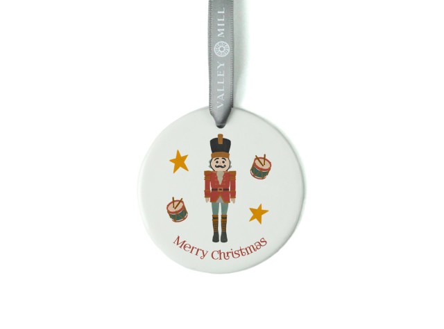White ceramic christmas tree decoration with the image of a cute nutcracker soldier